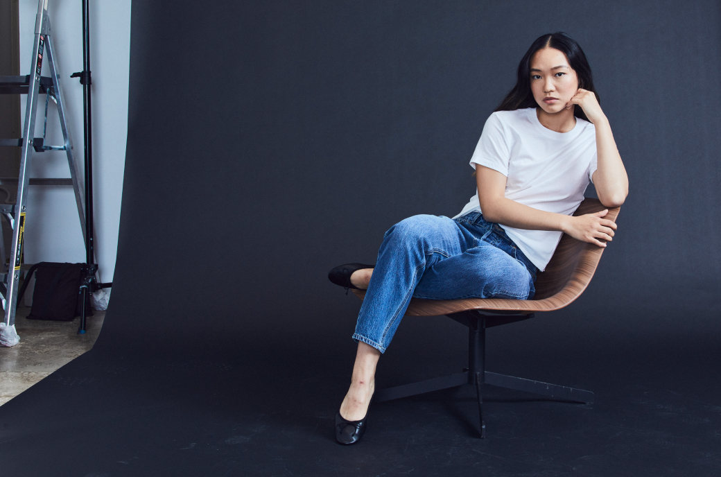 Model sitting in chair wearing blue jeans and white t-shirt