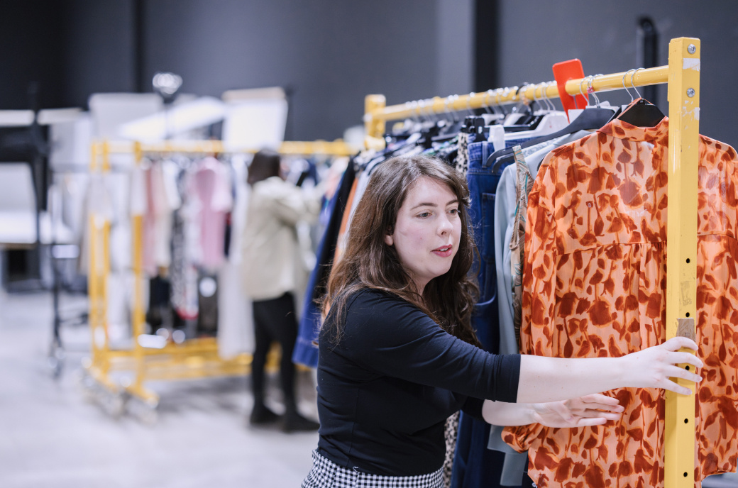 Woman moving rack with clothes